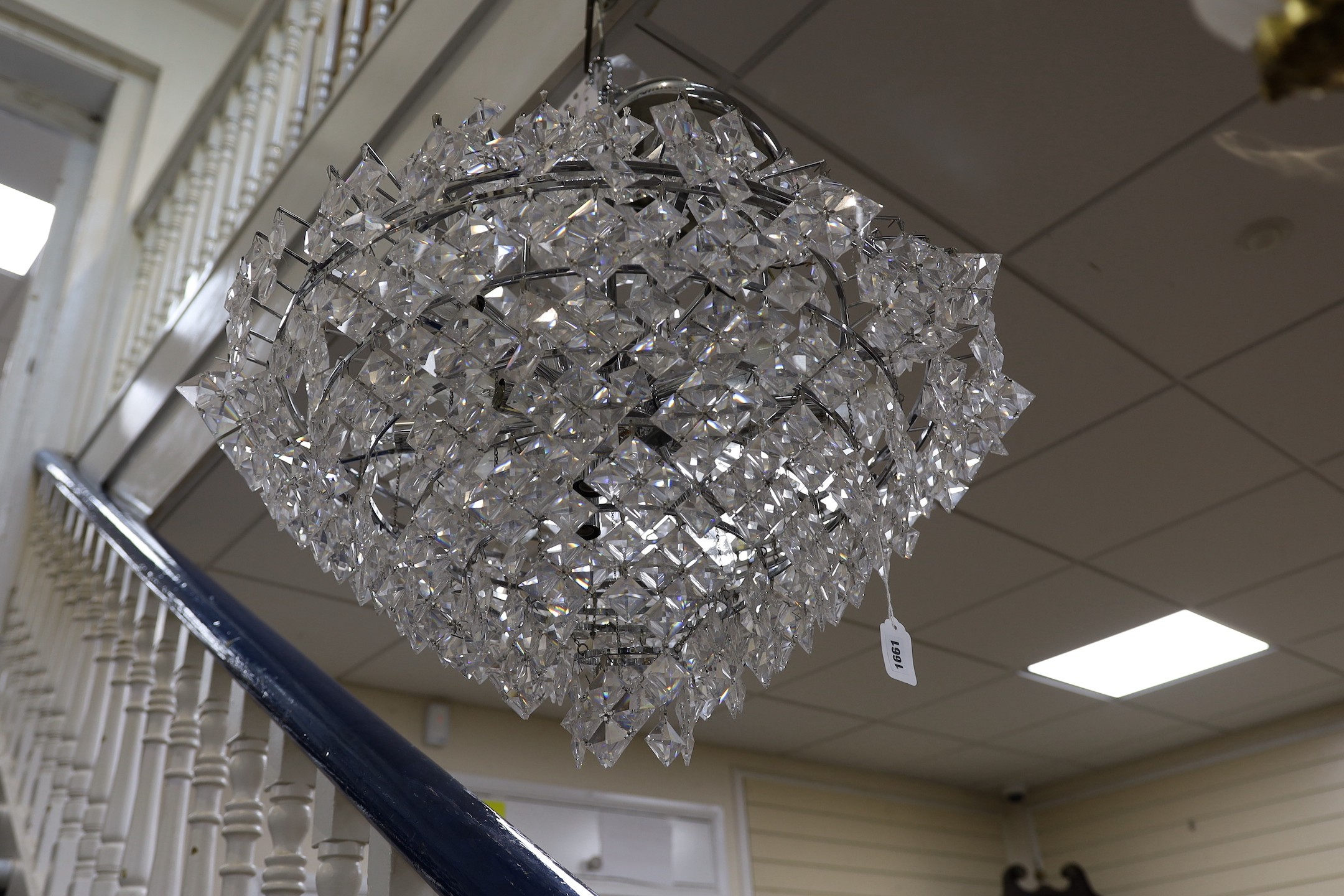 A ten tier, eighteen light, graduated chrome chandelier, with diamond shaped clear perspex drops